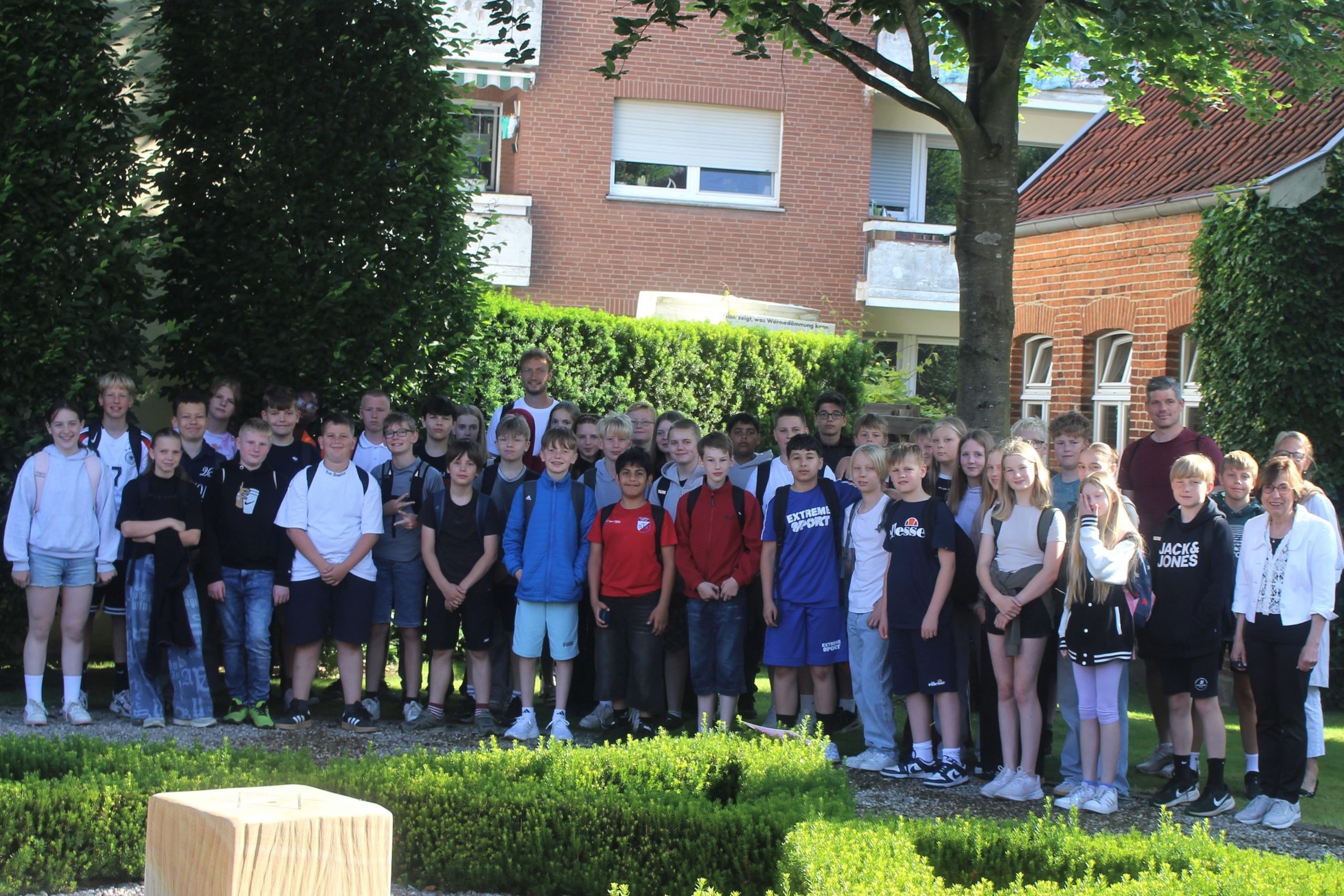 Die Klassen 6d und 6e der Johannesschule Meppen mit den Lehrern Robert Bartling (li) und Klaus Lammers vor dem Gedenkort Jüdische Schule. Rechts Anne Gottschalk, daneben Angela Prenger