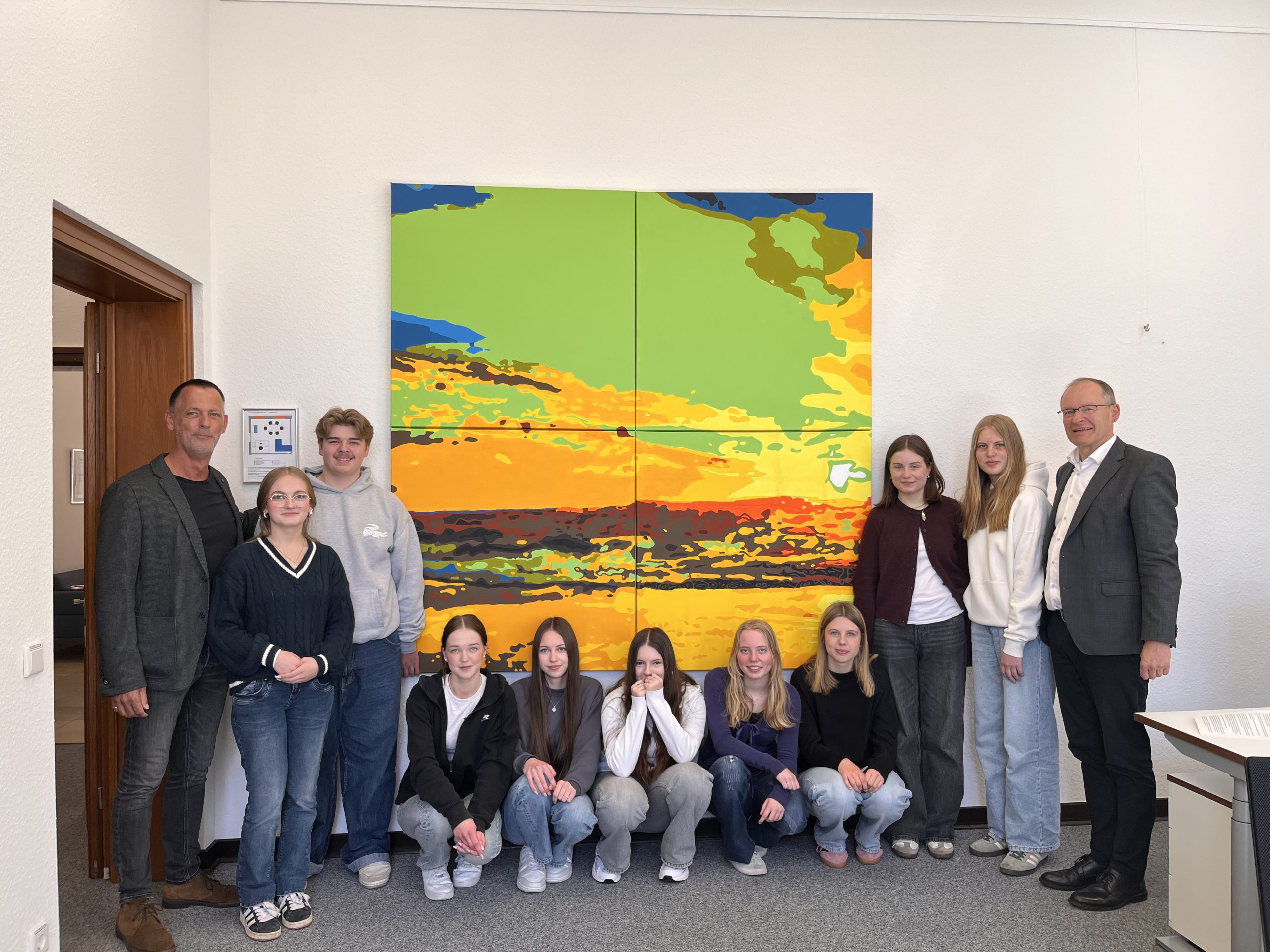 Schülerinnen und Schüler der 10. Klasse der Thomas-Morus-Schule (TMS) und ihr Kunstlehrer Andreas Arlinghaus-Deutschmann übergeben das von ihnen gestaltete Bild an Generalvikar Ulrich Beckwermert.